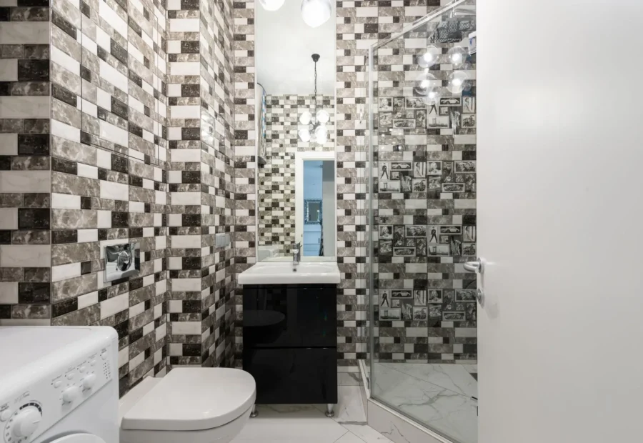 Inspirasi desain kamar mandi minimalis modern dengan partisi kaca dan pencahayaan hangat