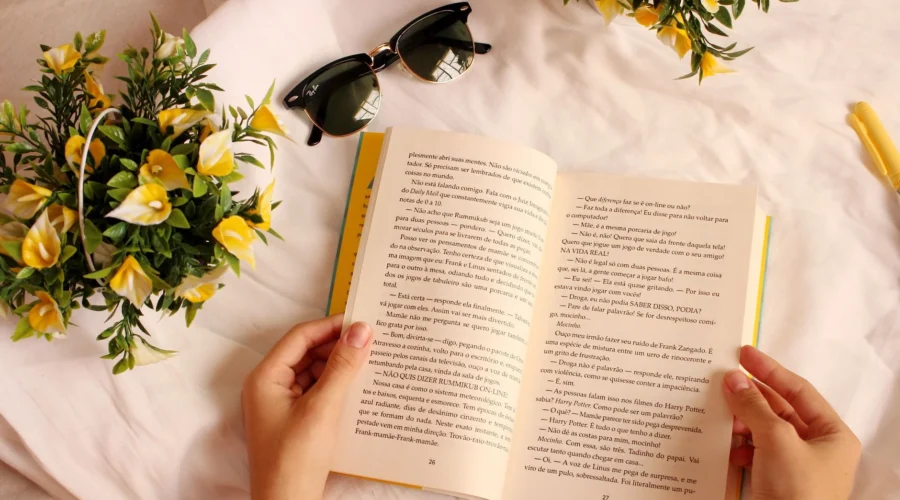Seorang wanita sedang santai membaca buku favoritnya di sudut kamar yang estetis dan nyaman