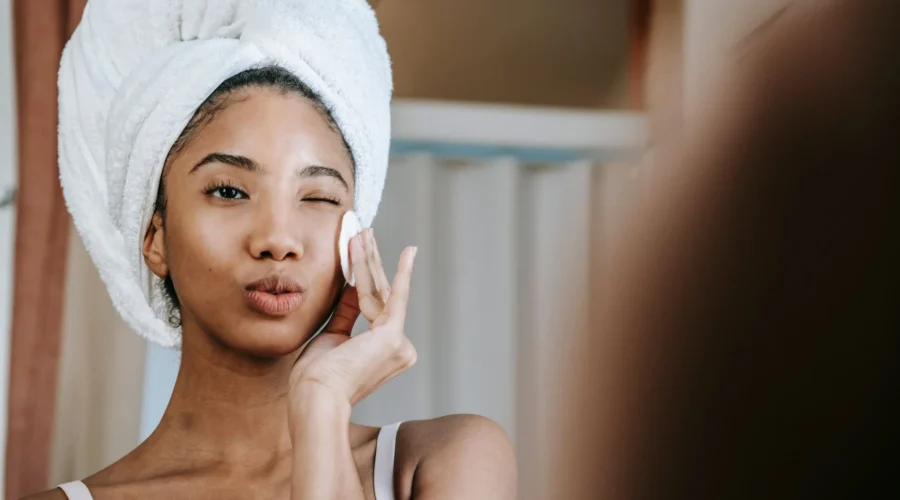 Seorang wanita sedang mengaplikasikan toner wajah dengan lembut untuk tips memilih toner yang tepat sesuai jenis kulit