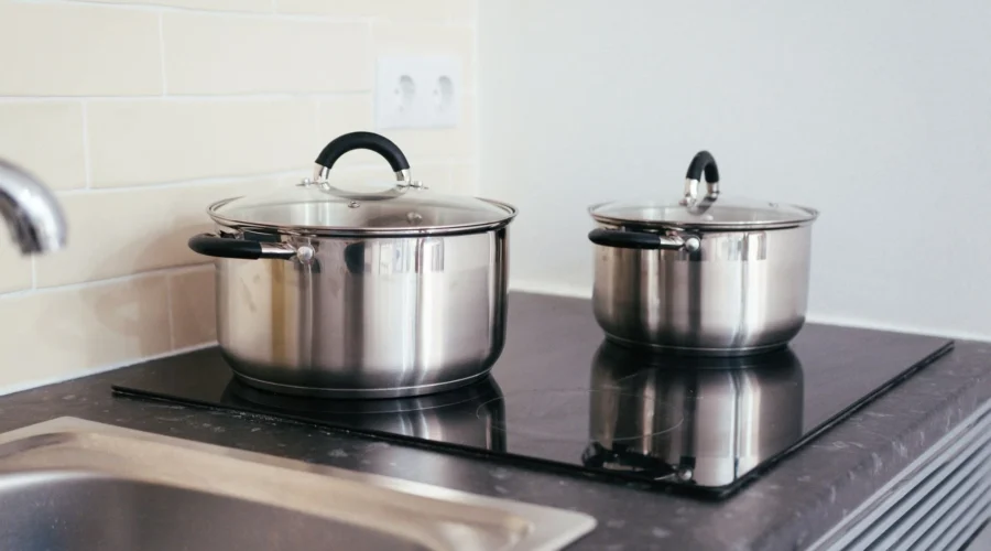 Deretan wajan dan panci stainless steel di rak dapur yang fungsional dan awet