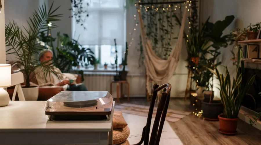 Dekorasi kamar gaya bohemian dengan karpet anyaman rami dan tanaman hias hijau hangat