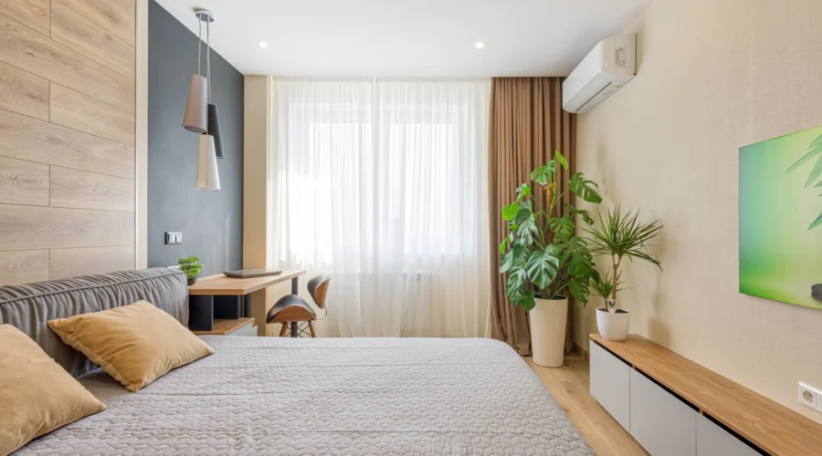 Unit AC rumah terpasang di dinding kamar tidur minimalis yang rapi