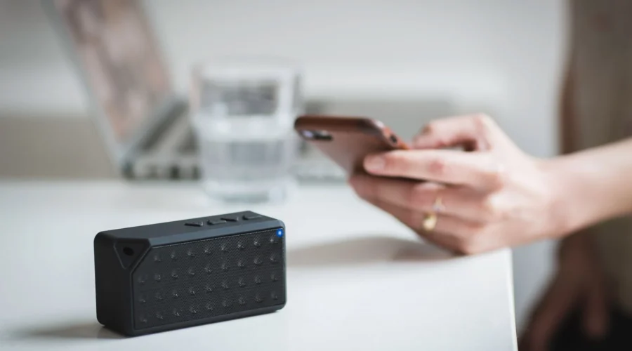 Ilustrasi tips memilih speaker bluetooth portable ringkas di atas meja kayu