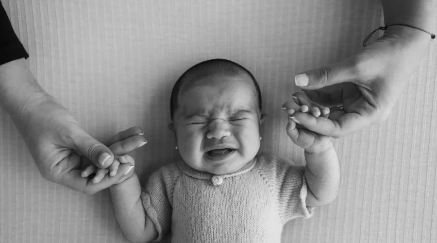 Tips mengasuh anak sebagai orang tua baru saat menenangkan bayi di rumah