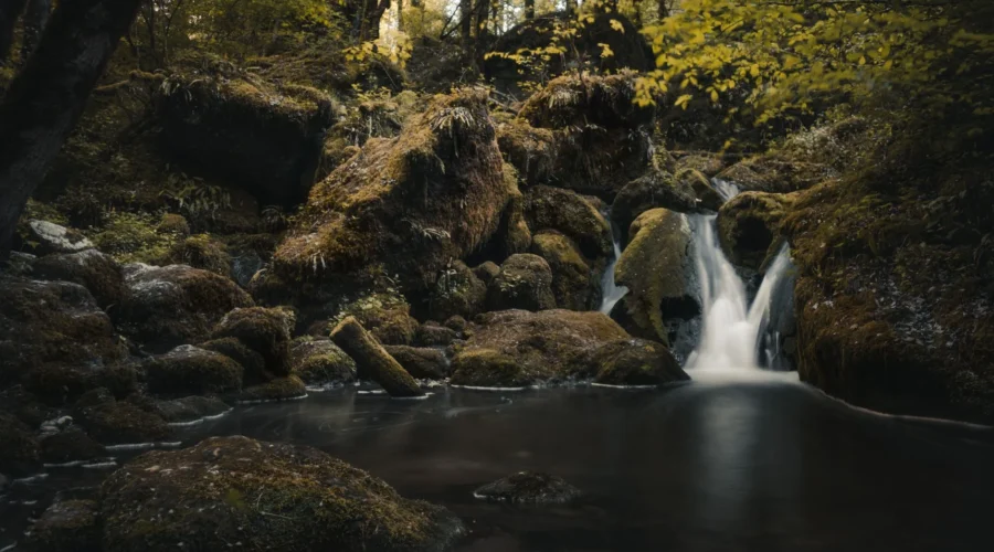 Pemandangan air terjun tersembunyi di kawasan tebing hijau yang asri dan sepi pengunjung